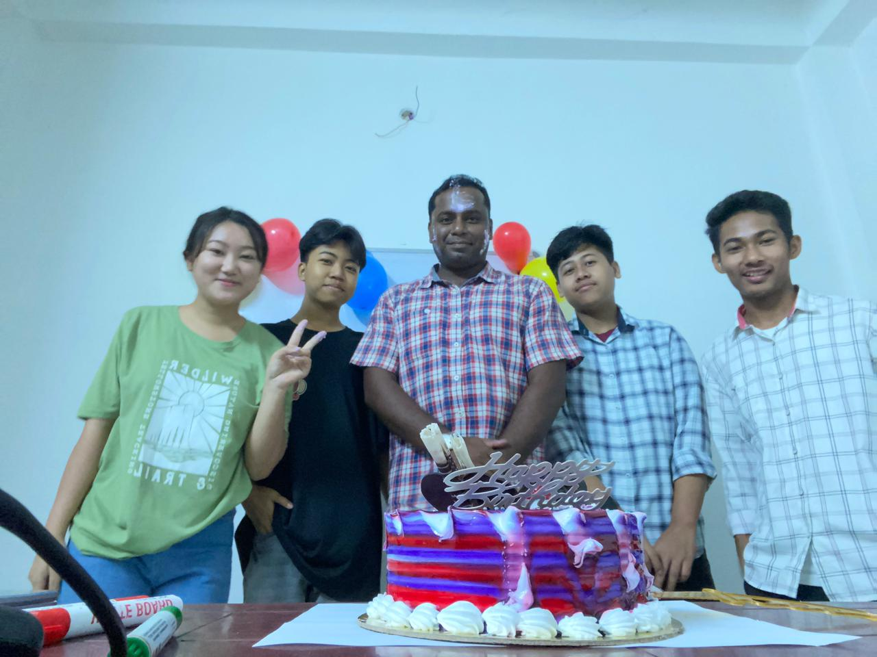 Students celebrating a birthday with their teacher at the academy